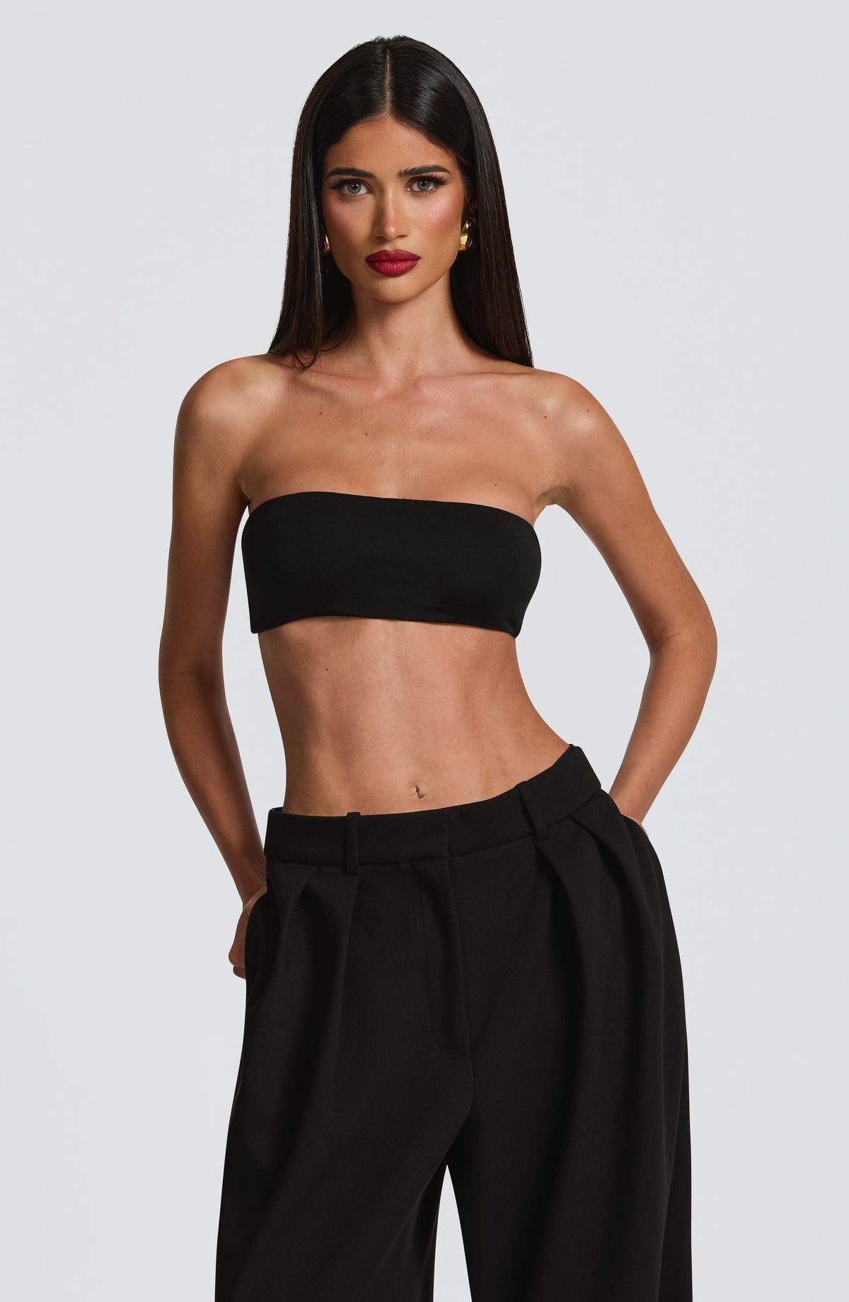 Top bandeau negro sin tirantes, con borde elástico y ajuste ceñido.